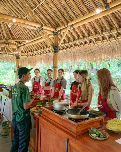 Tourists participating in an authentic Balinese cooking class experience arranged organized by Bali Assist Co luxury tour