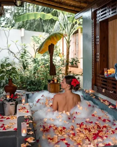 Woman relaxing in traditional Balinese flower bath at luxury spa resort for curated experiences service by Bali Assist Co