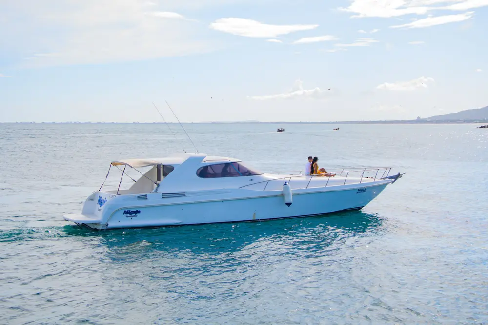 Couple relaxing on luxury private yacht charter sailing along Bali coastline by Bali Assist Co
