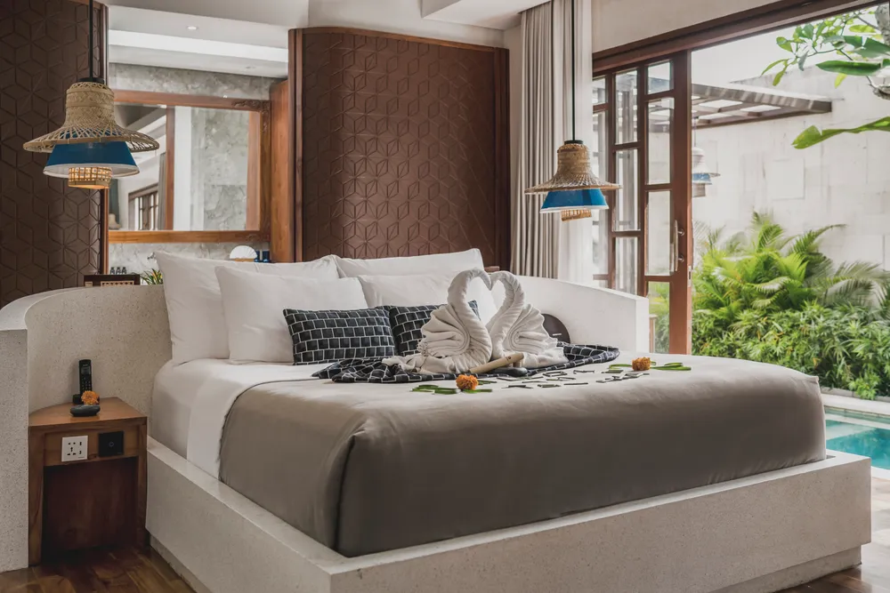 Luxury honeymoon villa bedroom with romantic towel swans arrangement in Bali curated by Bali Assist Co