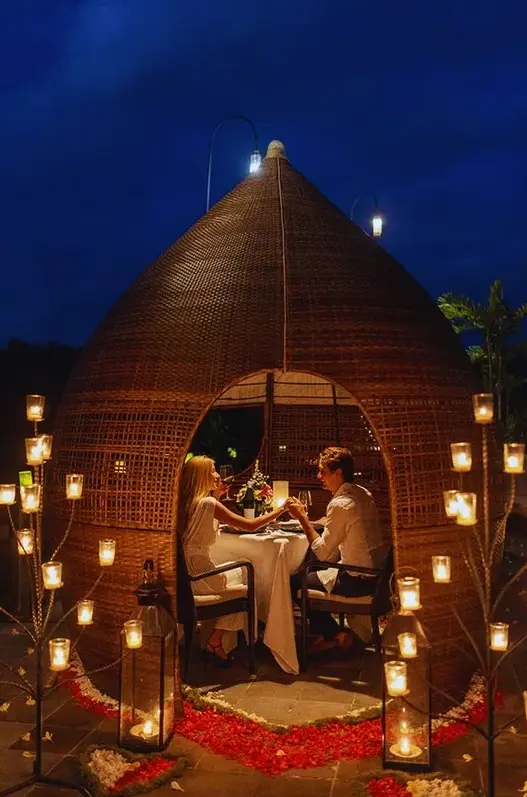 Couple having an intimate romantic dinner inside a bamboo dome with candle lights by Bali Assist Co