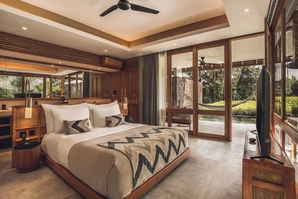 Luxury private villa master bedroom with wooden interior and lush tropical jungle view in Bali by Bali Assist Co