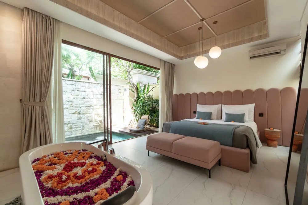 Romantic luxury villa bedroom with a flower bath tub overlooking private pool in Bali curated by Bali Assist Co