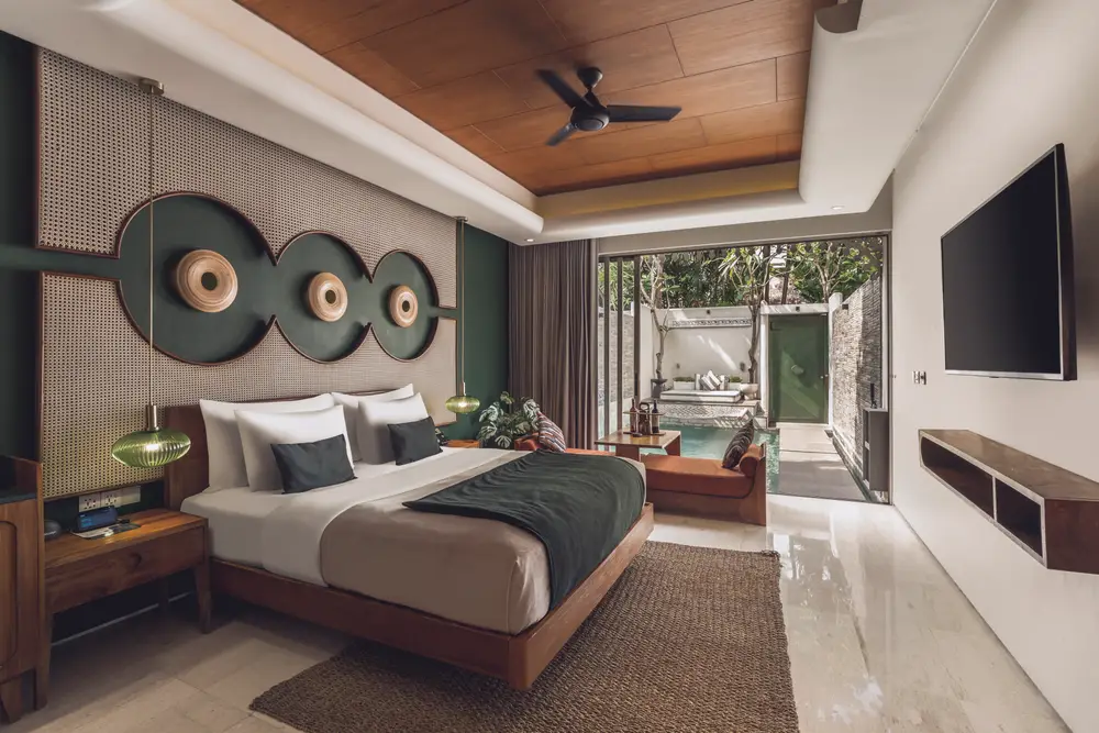 Modern tropical villa bedroom opening directly to a private swimming pool in Bali curated by Bali Assist Co