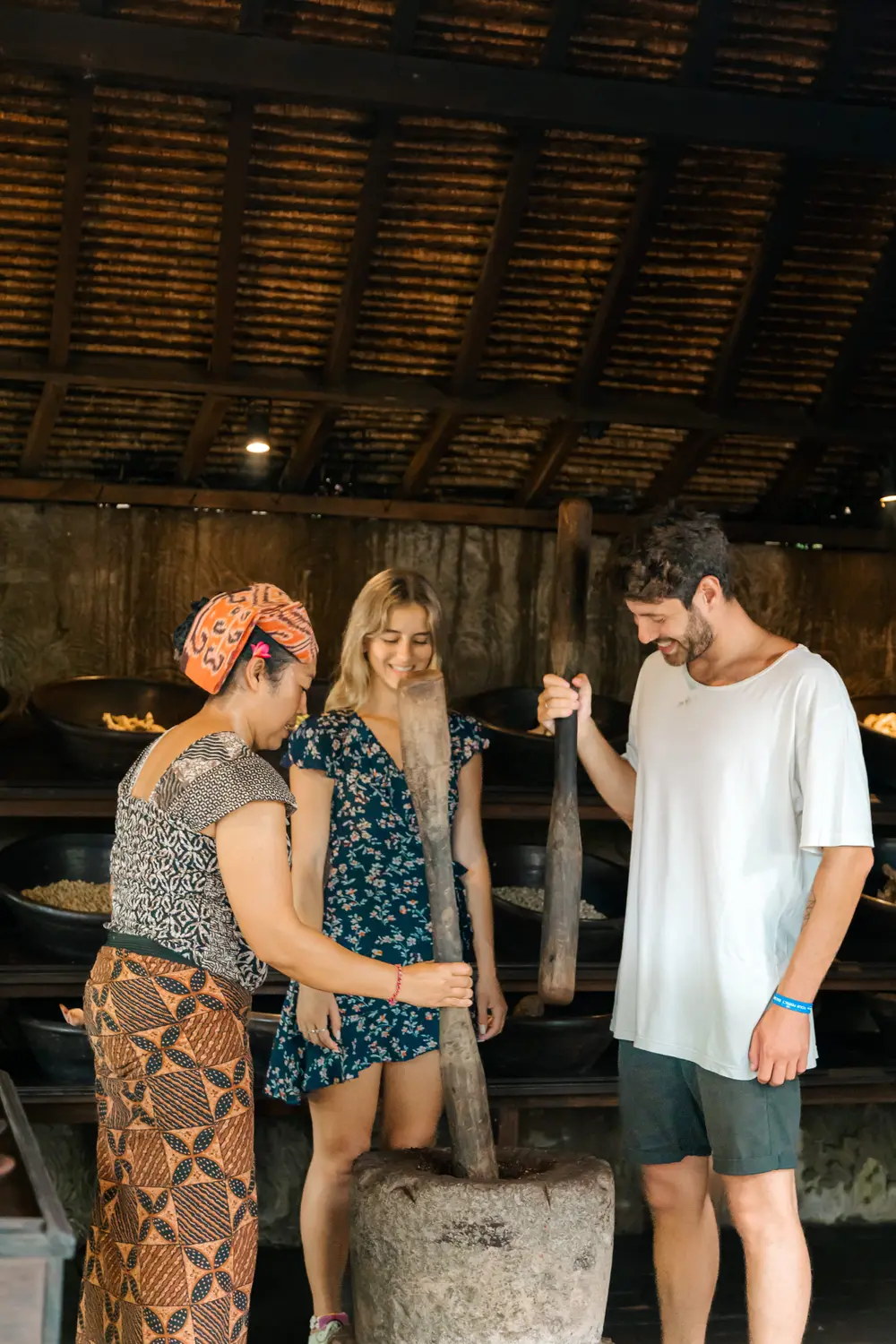 Couple learning traditional Luwak coffee grinding process at Alas Harum Ubud for The Discovery Day 3 by Bali Assist Co