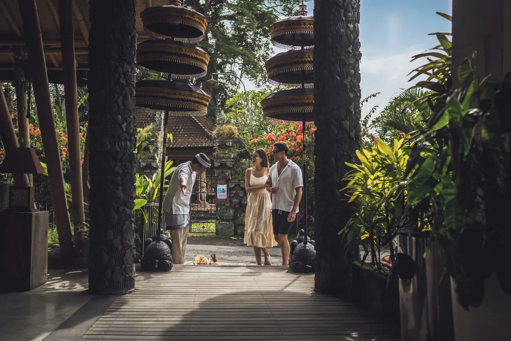 Couple warmly welcomed by staff in traditional Balinese attire at Ubud resort for The Discovery package by Bali Assist Co