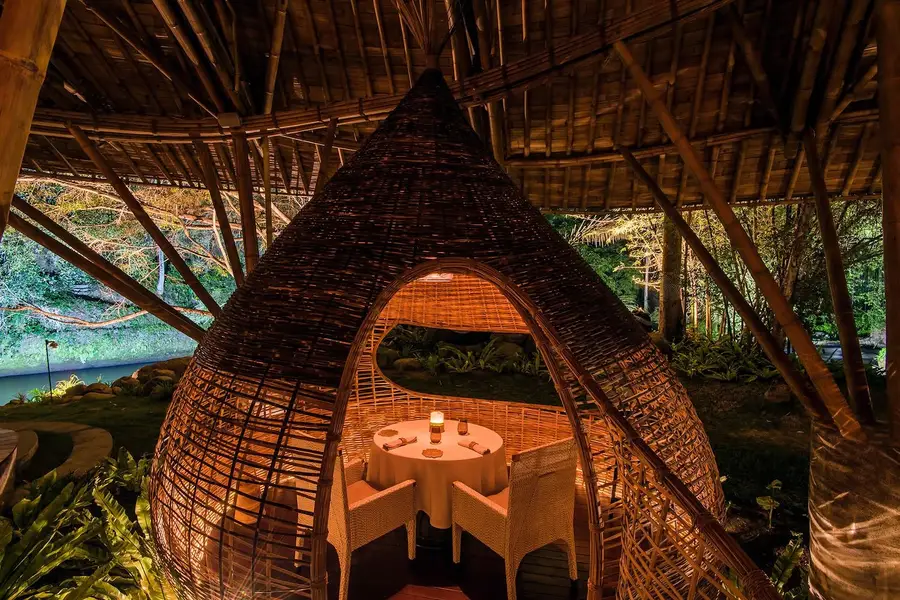 Private candlelit dining table inside a bamboo cocoon at Kubu at Mandapa Ubud for The Grand Escape by Bali Assist Co