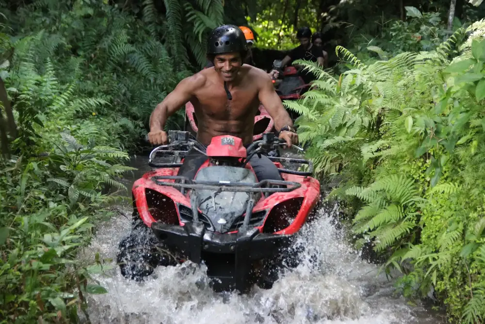 Man driving ATV quad bike through jungle river trail in Ubud for The Grand Escape Day 6 by Bali Assist Co