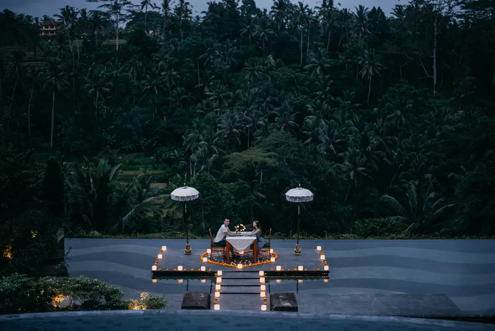 Romantic luxury candlelight dinner setup for couples overlooking jungle valley for The Indulgence Bali package by Bali Assist Co