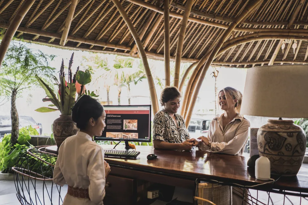 Guest checking in at Seminyak resort reception desk for The Indulgence Day 1 by Bali Assist Co