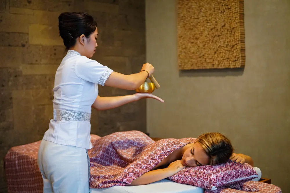 Woman receiving relaxing spa massage with sound healing singing bowl in Seminyak for The Indulgence Day 2 by Bali Assist Co