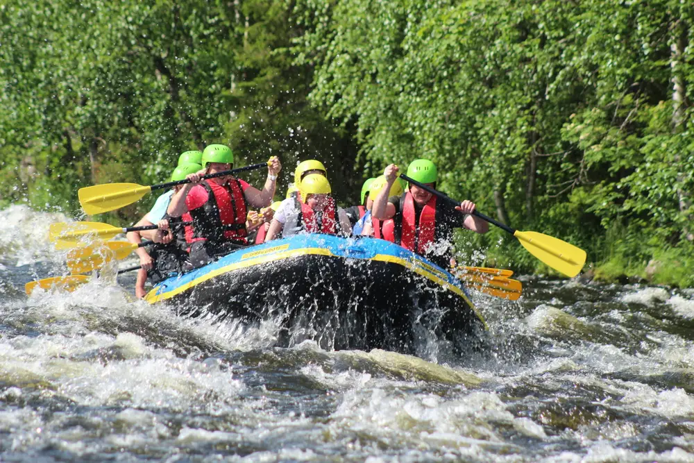 Tourists paddling through splash waves during white water rafting adventure in Ubud for The Journey Day 3 by Bali Assist Co