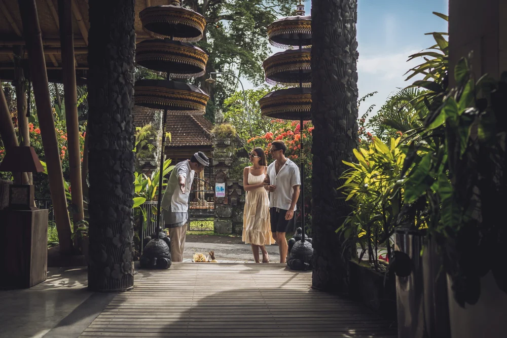 Couple warmly welcomed by staff in traditional Balinese attire at Ubud resort for The Journey package by Bali Assist Co