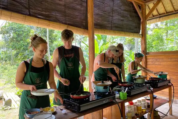Participants cooking traditional Balinese dishes on stove during hands-on class for The Signature Journey Day 7 by Bali Assist Co