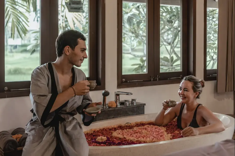 Couple enjoying relaxing herbal tea during flower bath spa treatment in Seminyak for The Signature Journey Day 2 by Bali Assist Co