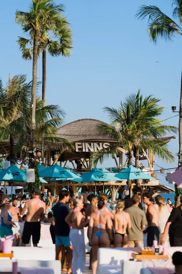 Visitors relaxing on daybeds by the pool at Finns Beach Club Canggu for The Signature Journey Day 3 by Bali Assist Co