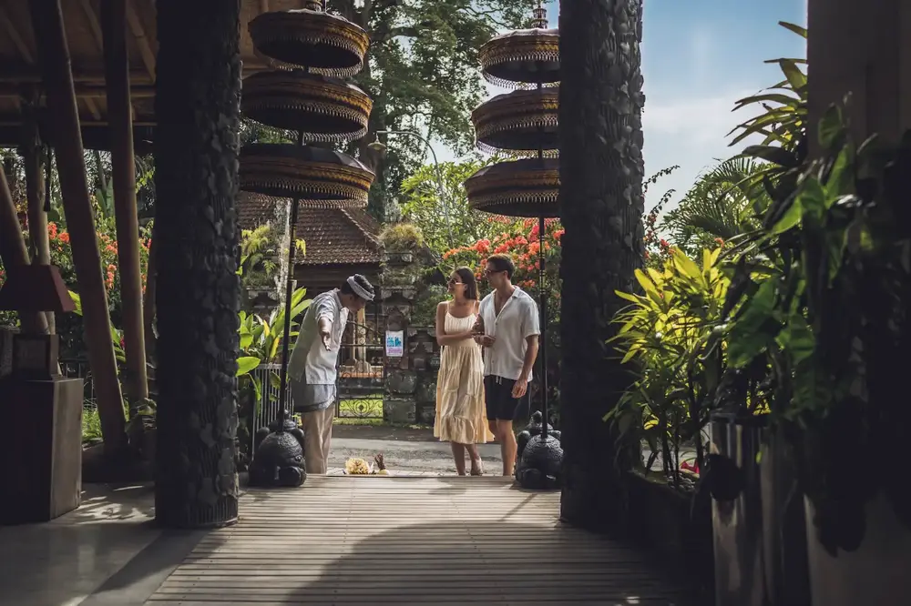 Couple receiving traditional Balinese welcome greeting at resort entrance for The Signature Journey by Bali Assist Co