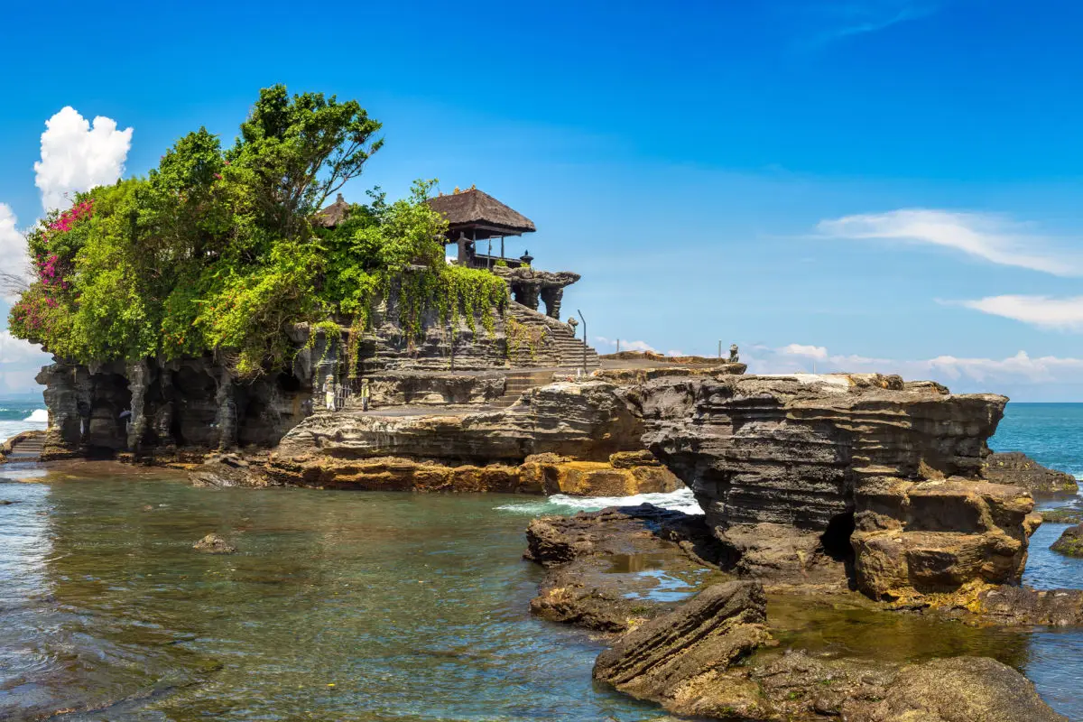 Tanah Lot sea temple sitting on a rock formation in the ocean for The Signature Journey by Bali Assist Co