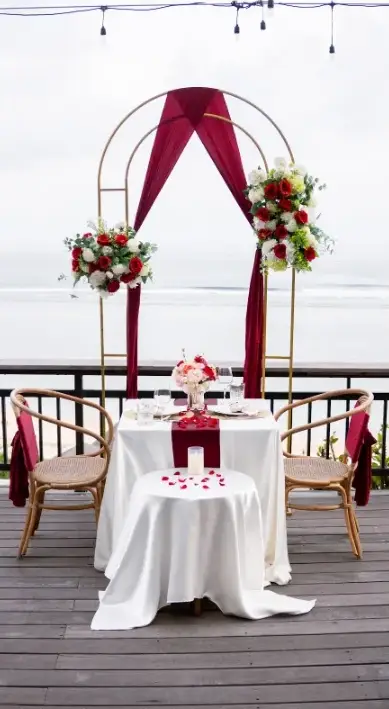 Private candlelit dinner table with flower arch at The Cliff at Canna for The Signature Journey Day 9 by Bali Assist Co