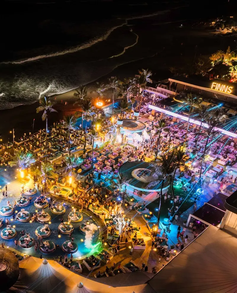 Aerial night view of illuminated pools and venue at Finns Beach Club Canggu by Bali Assist Co