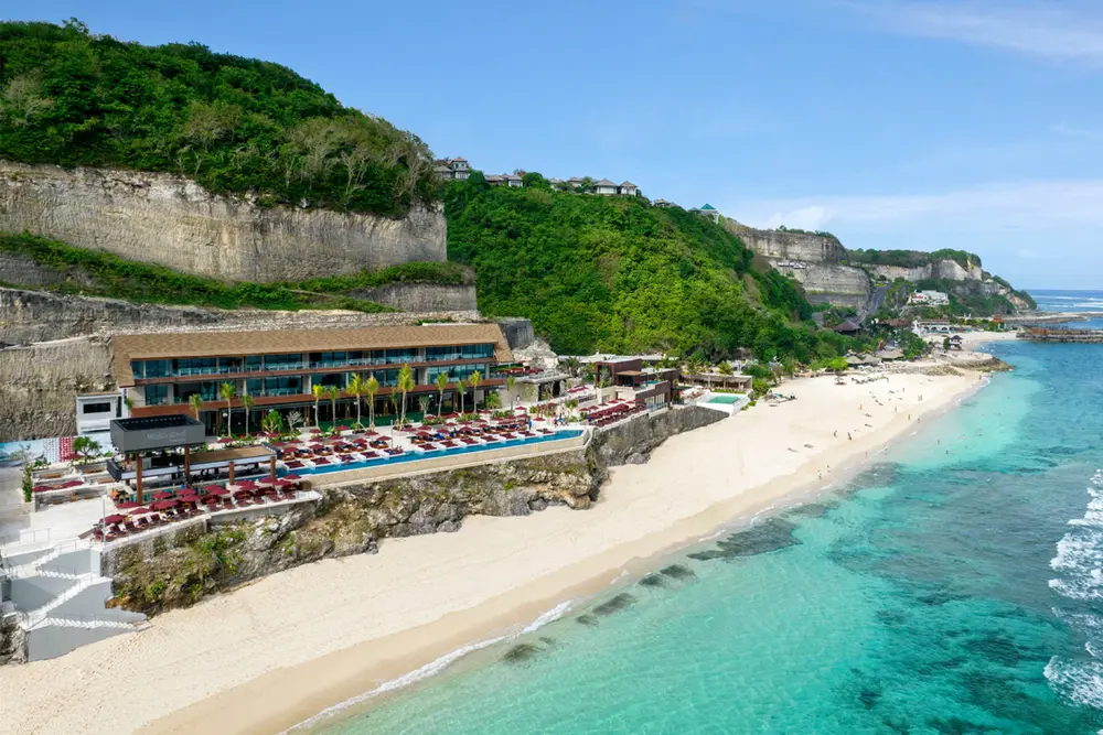 Limestone cliff and luxury beach club overlooking turquoise sea at Melasti Beach Ungasan by Bali Assist Co