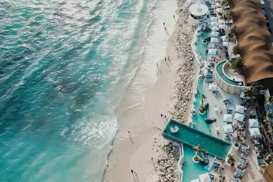 Aerial view of white sand beach and turquoise ocean shoreline at Melasti Beach Bali by Bali Assist Co