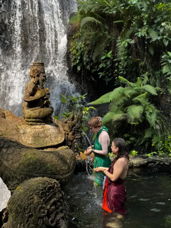 Tourists performing Melukat water purification ritual at Taman Beji Waterfall Ubud for The Ultimate Bali Journey Day 10 by Bali Assist Co