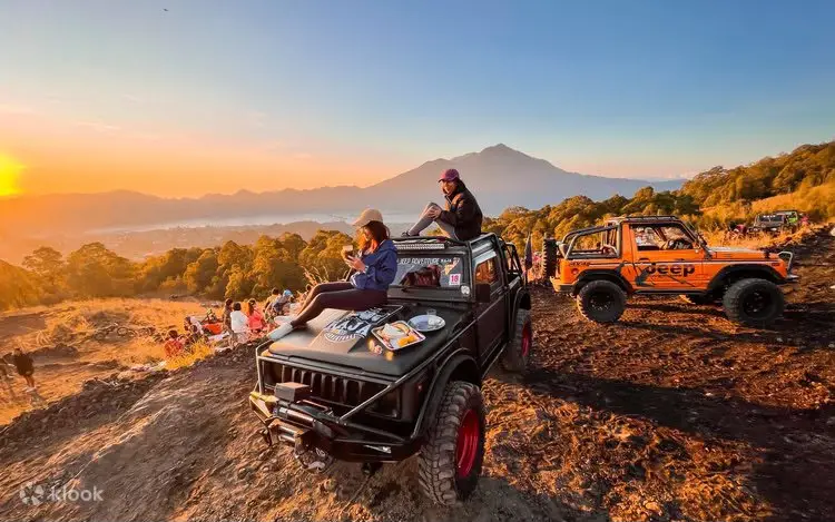 Tourists enjoying breakfast on 4WD jeep hood with Mount Batur volcano view in Kintamani Bali by Bali Assist Co