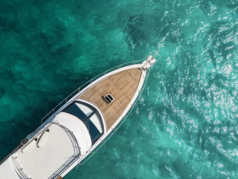 Aerial view of wooden deck of luxury yacht cruising clear turquoise waters to Nusa Penida for The Ultimate Bali Journey Day 11 by Bali Assist Co