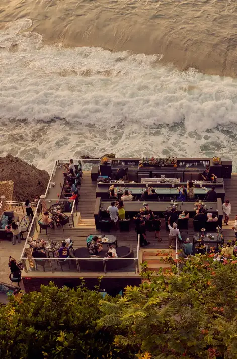 Open-air lounge and bar seating on cliff edge over crashing waves at Rock Bar Ayana Bali for The Ultimate Bali Journey Day 13 by Bali Assist Co