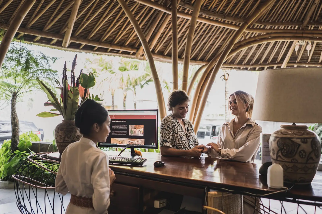 Couple checking in at luxury resort reception desk in Seminyak Bali for The Ultimate Bali Journey Day 1 by Bali Assist Co