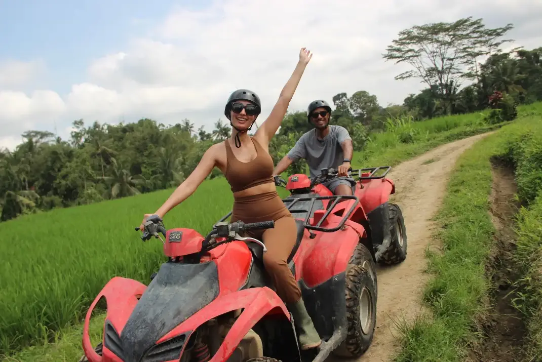 Tourist riding red ATV quad bike through Ubud jungle trail for The Ultimate Bali Journey by Bali Assist Co
