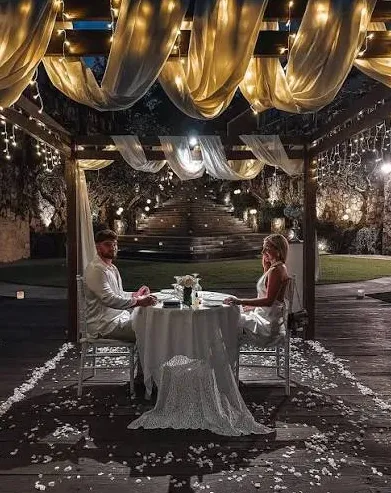Couple enjoying an intimate romantic candlelight dinner in an elegant outdoor setting for Day 3 by Bali Assist Co