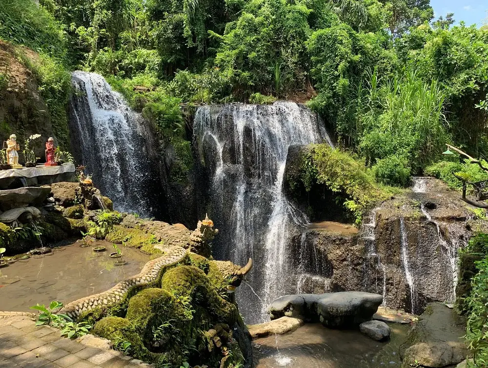 Scenic tropical waterfall in Ubud as a holy water purification site for Day 4 itinerary by Bali Assist Co